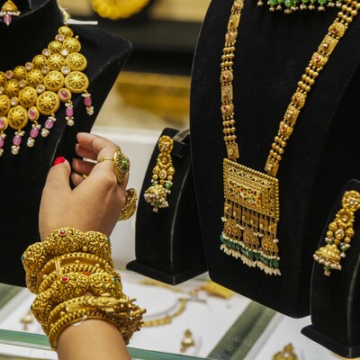 Gold biscuits and sovereign coins on a dark background showcasing Kerala gold rate updates.